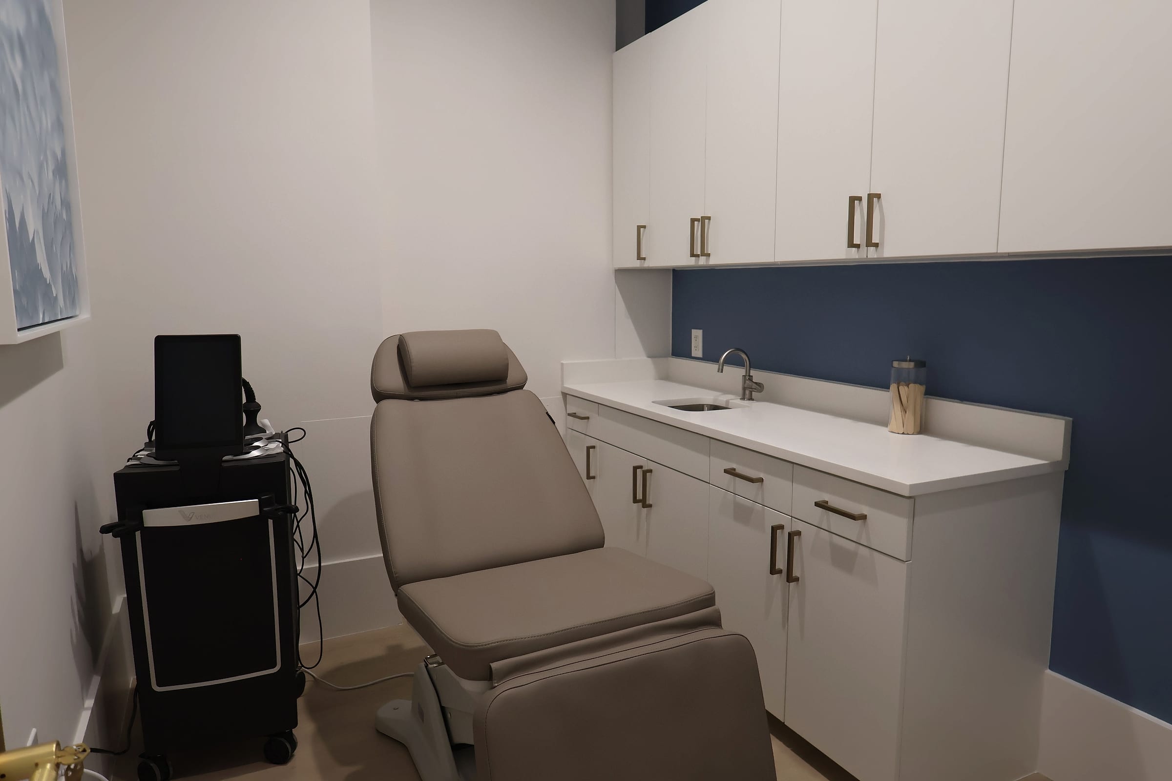 A treatment suite at Naiva with a reclining chair, equipment and cabinetry